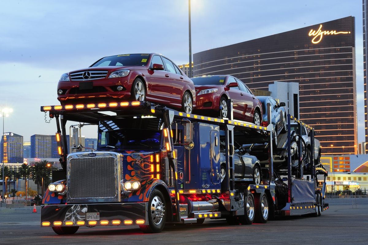 Multi-level auto transport truck loaded with cars at dusk